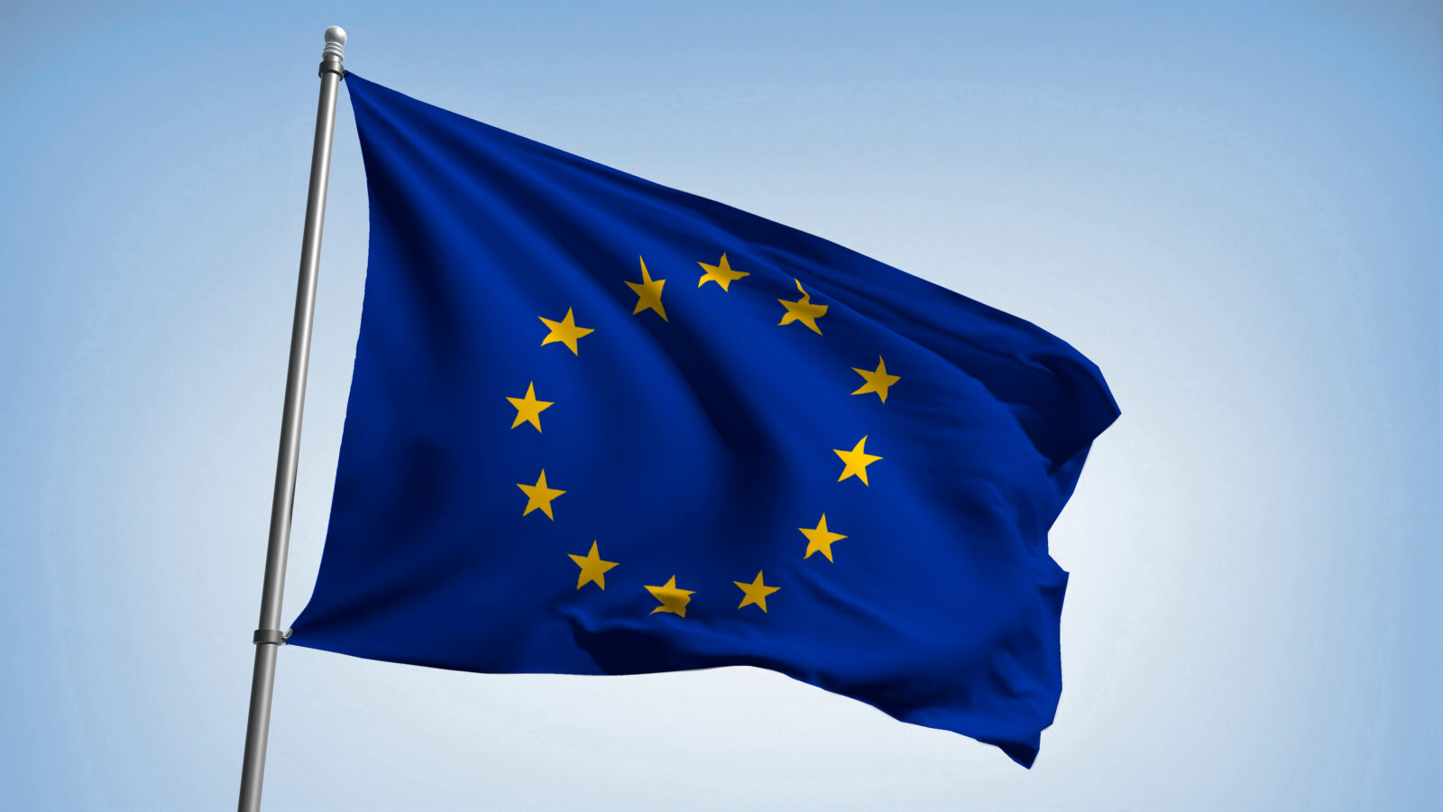 The European flag fluttering in the wind against a blue sky