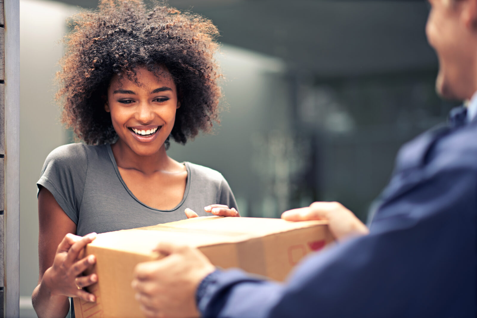 Shot of a courier making a delivery to a smiling customer