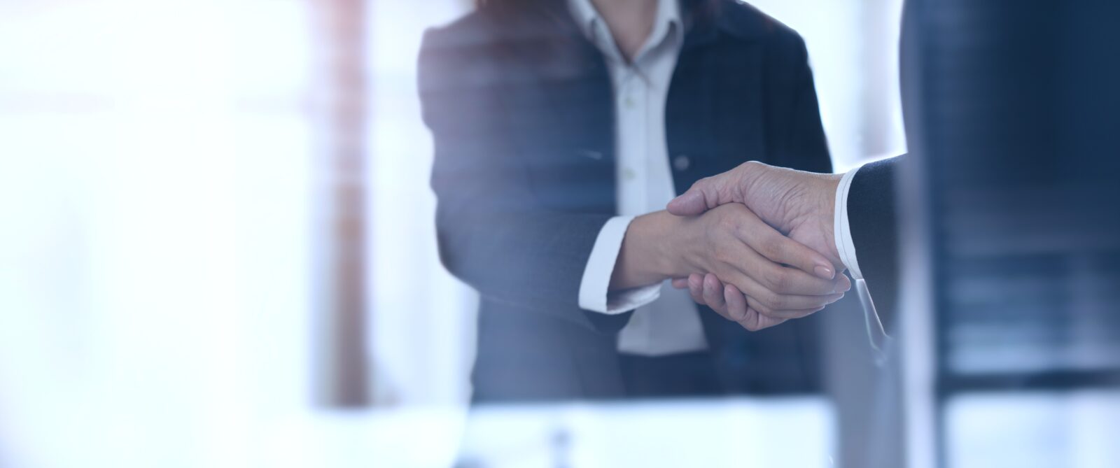 Two people shaking hands in a modern office setting